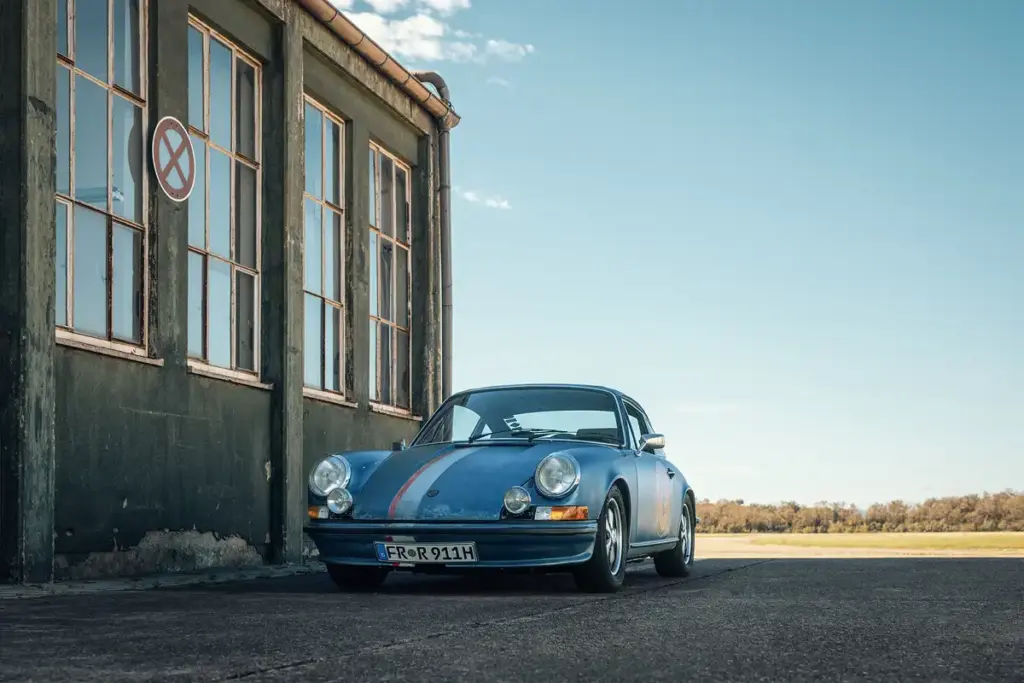Porsche 911 Rat Sportwagen vor Hangar auf Flugfeld bei exklusivem Car Shooting.